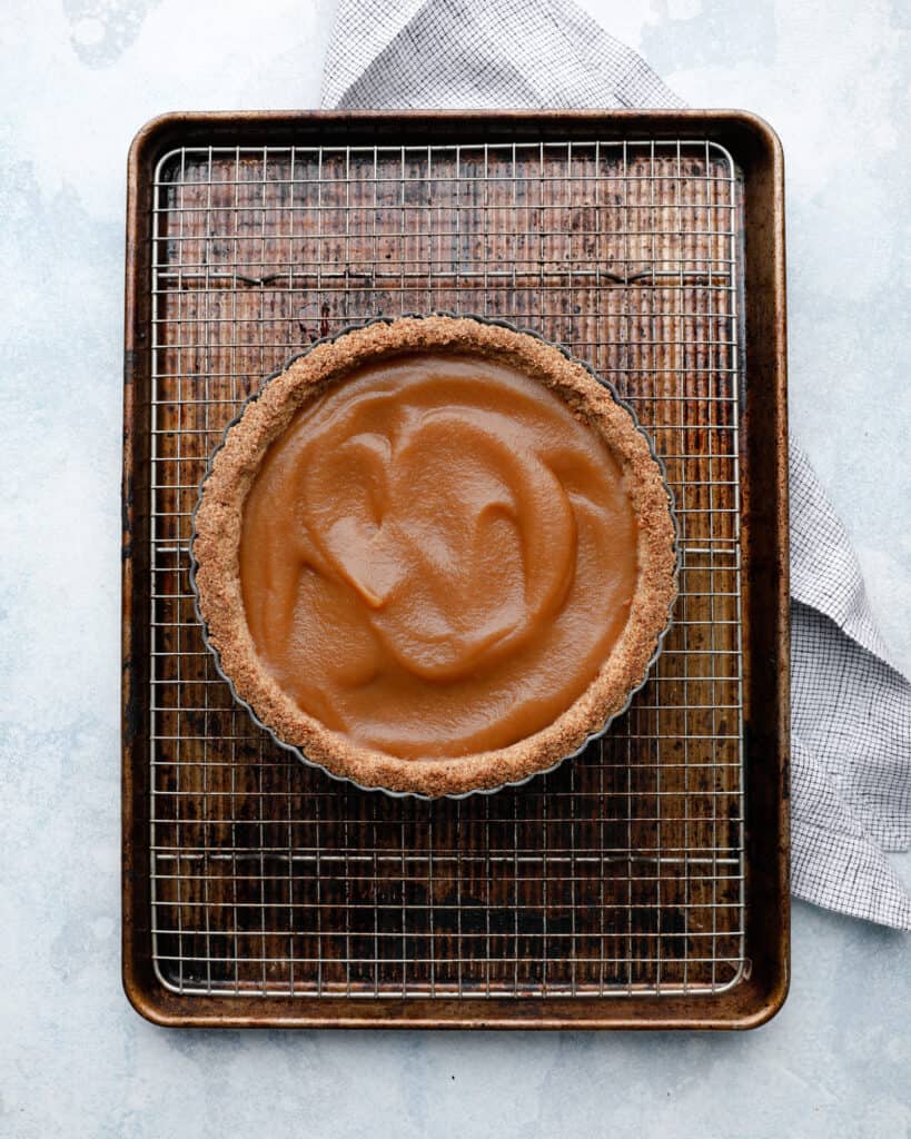 Ah overhead of an apple tart with apple butter in process on a wire baking rack