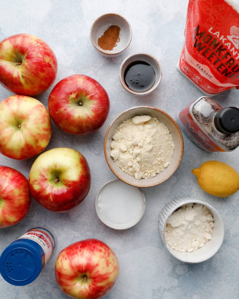 Overhead view of ingredients to make a gluten free apple tart including honeycrisp apples, monkfruit sweetener, almond flour and coconut flour