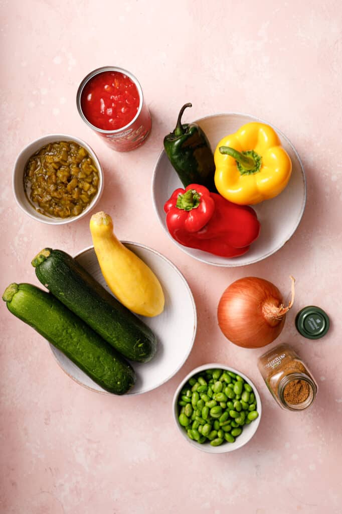 overhead view of vegetable ingredients for soup including tomatoes, peppers, and squash