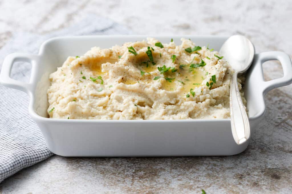 side view of a dish of cauliflower with pools of butter