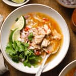 green chile pork stew in a bowl garnished with lime and cilantro