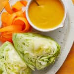 overhead view of dressing, lettuce and shredded carrots