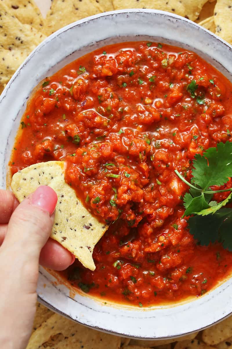 fresh homemade salsa being dipped with a chip