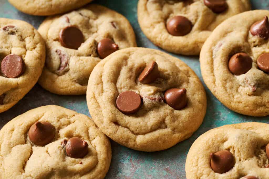 Side view of chocolate chip cookies on a green surface