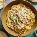 slow cooker angel chicken pasta with creamy sauce in a bowl with a fork