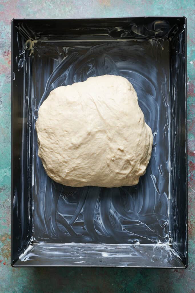 a greased 9 x 13 pan with the dough ready for second rise