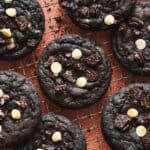Chocolate Cookies and Cream Cookies on a cooling rack with crumbs sprinkled around.