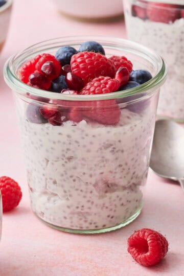 a chia yogurt parfait in a glass jar topped with berries