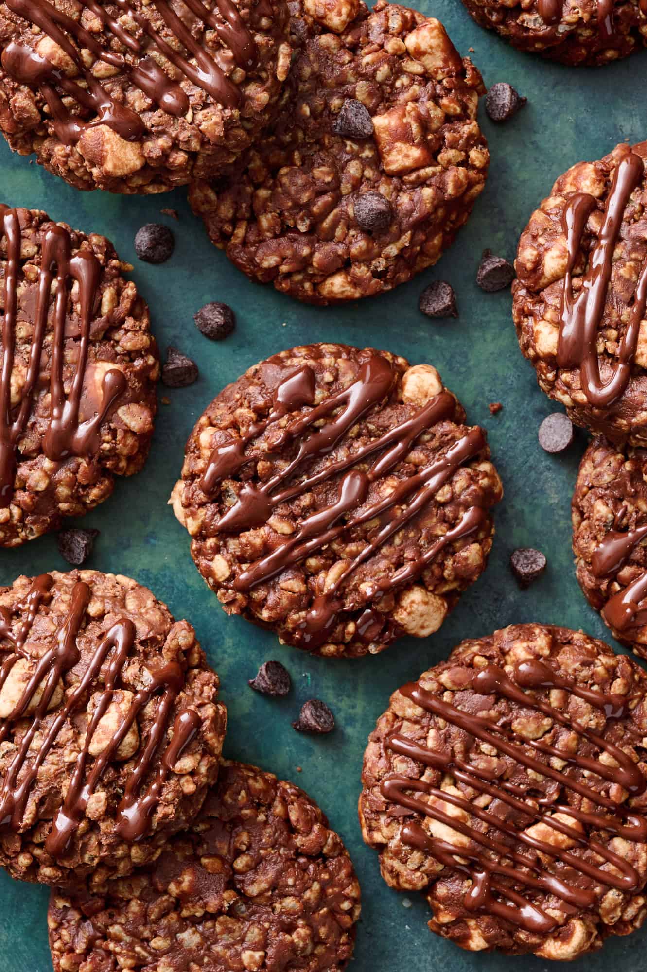 cookies on a green background drizzled with chocolate and chocolate chips