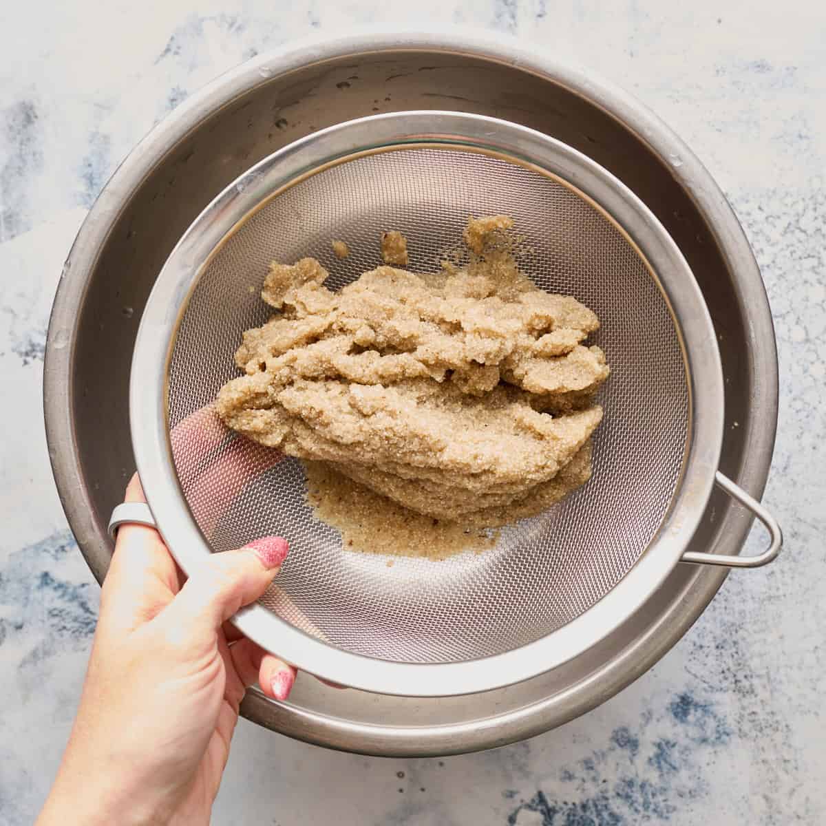 rinsing the fonio in a collander