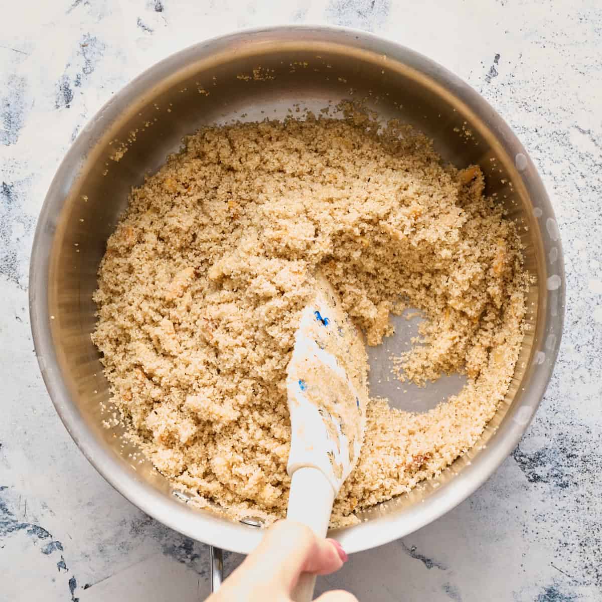 Adding the fonio to the almonds along with the aromatic spices and garlic