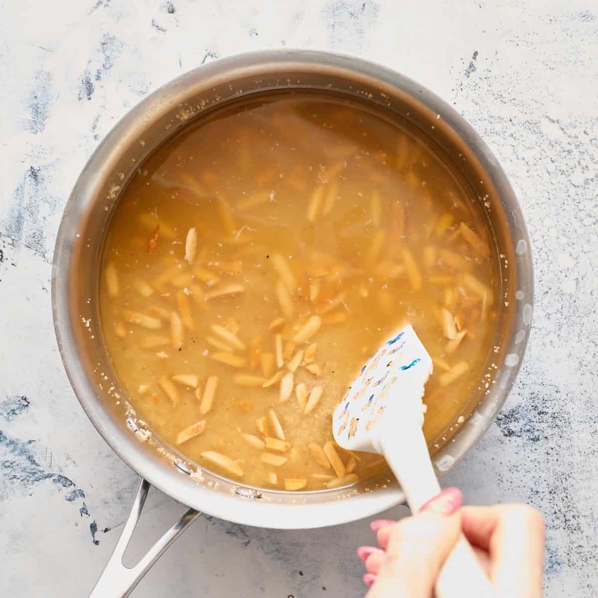 adding the broth to the pot with all the other ingredients
