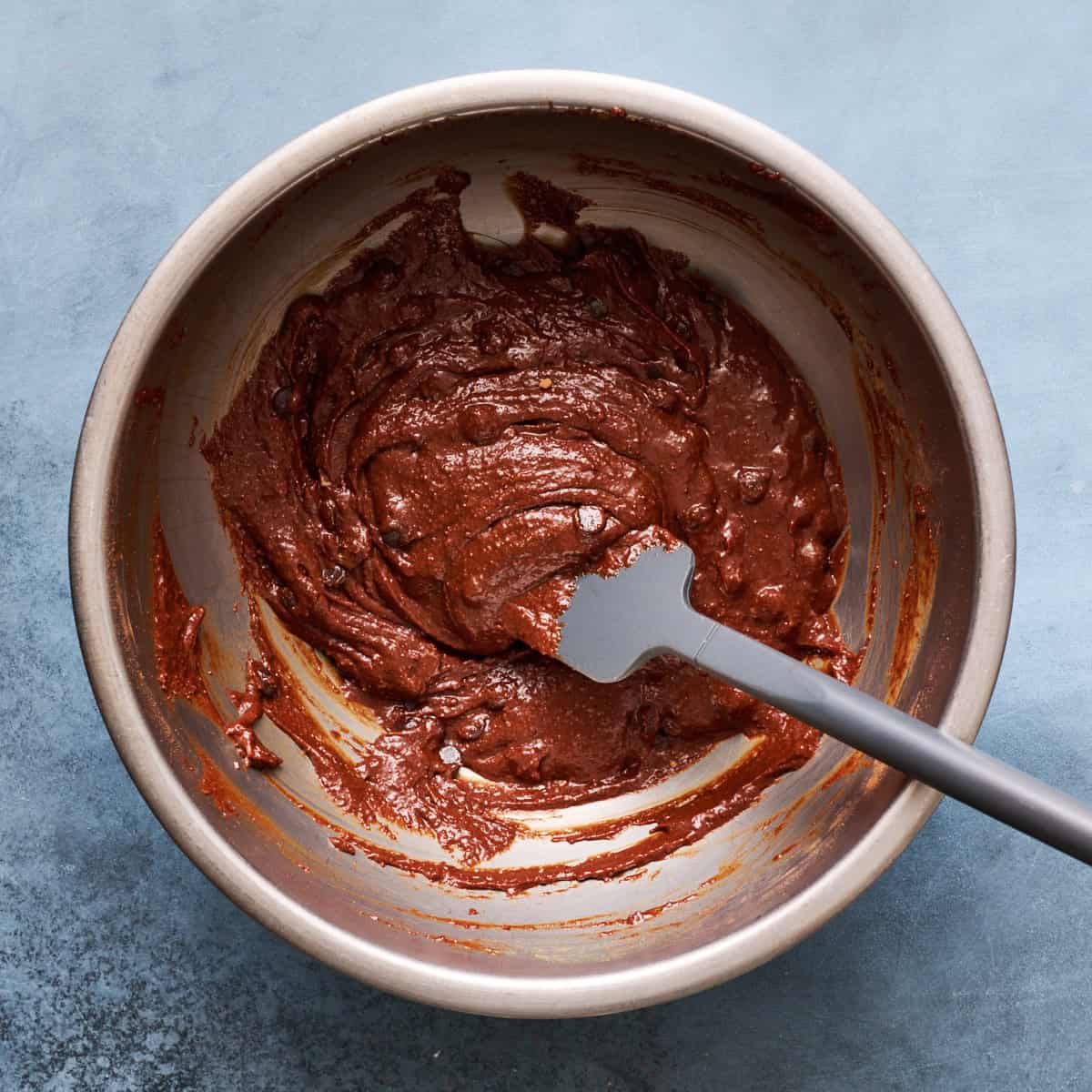brownie batter mixed in a mixing bowl with a spatula