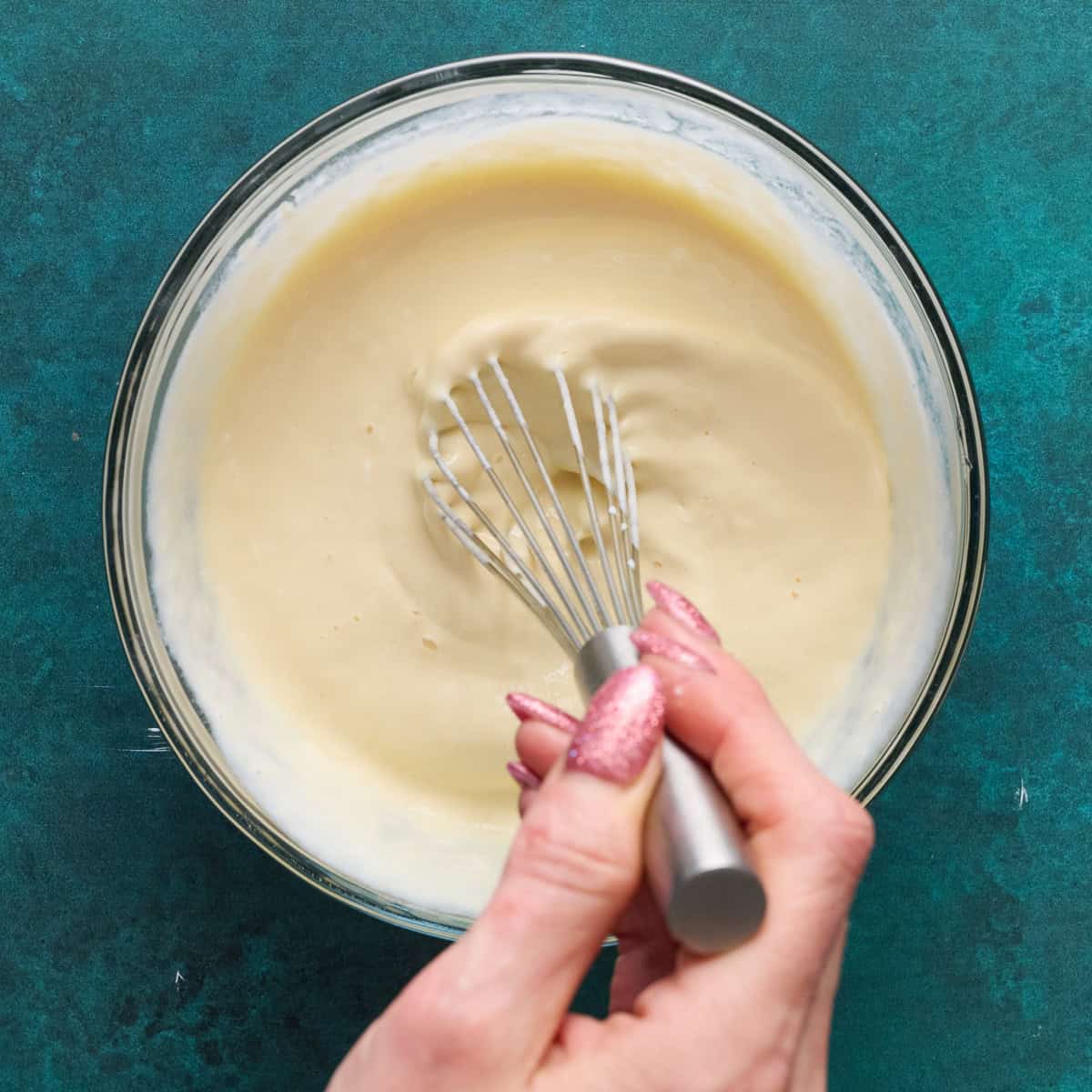 whisking wet ingredients together a glass bowl