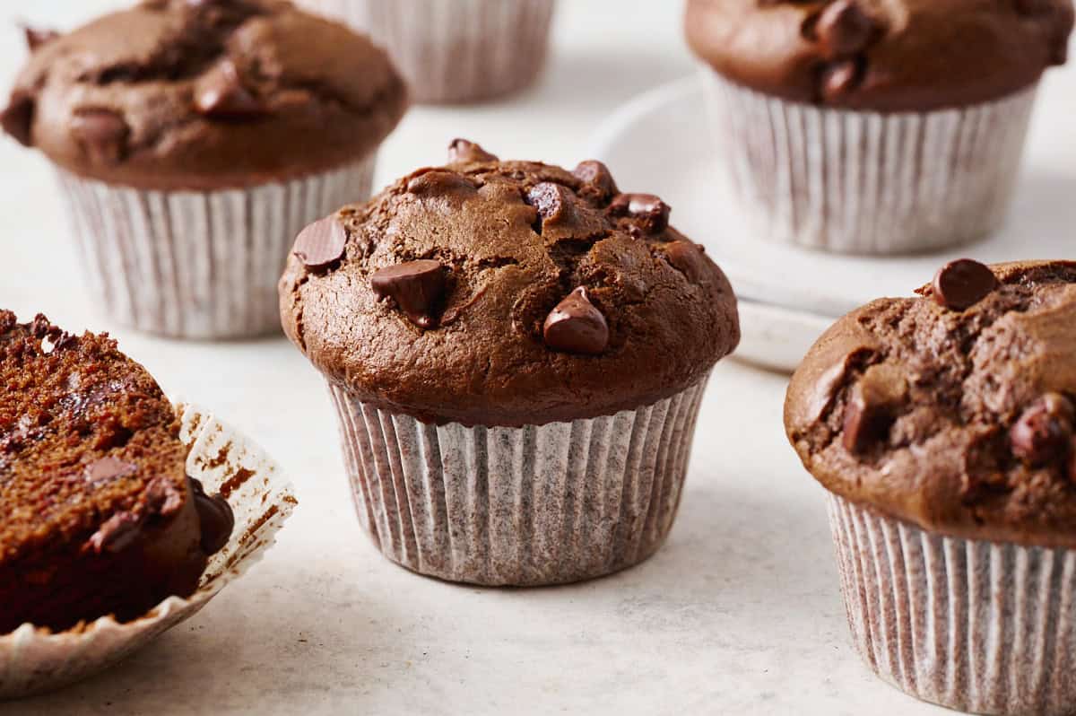 sourdough chocolate muffins with shiny chocolate chips on a countertop