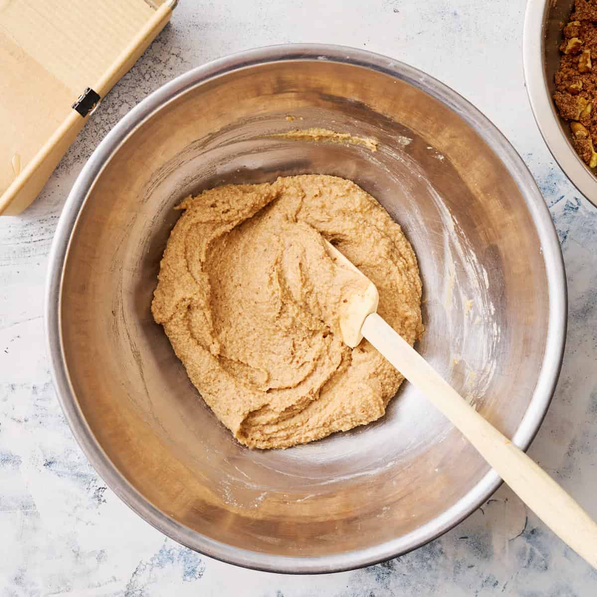 the wet and the dry cake ingredients combined to make a batter in a bowl with a spatula
