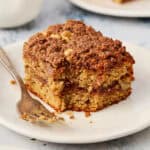 a slice of coffee cake on a plate with a fork with a bite taken out