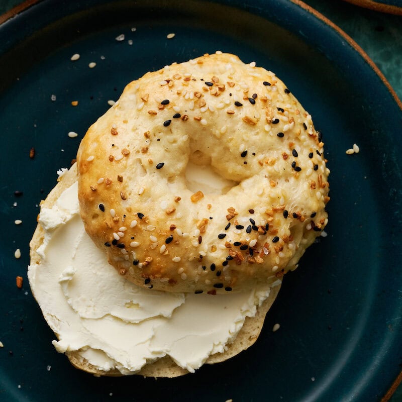 Bagel sliced on a plate with cream cheese