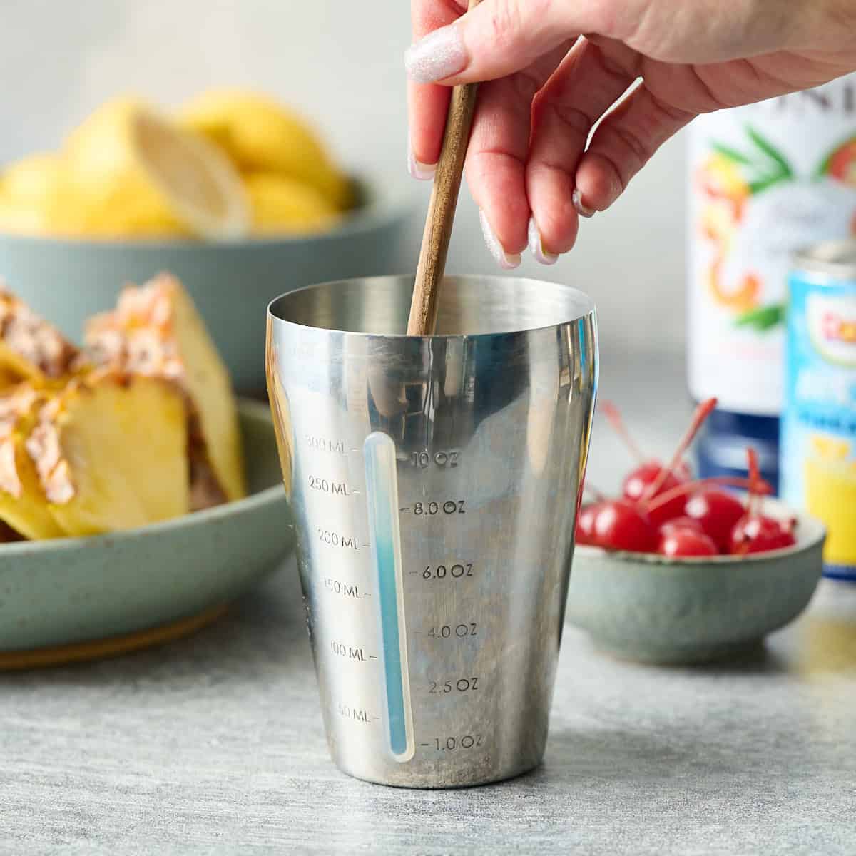 stirring the ingredients in a shaker with a spoon