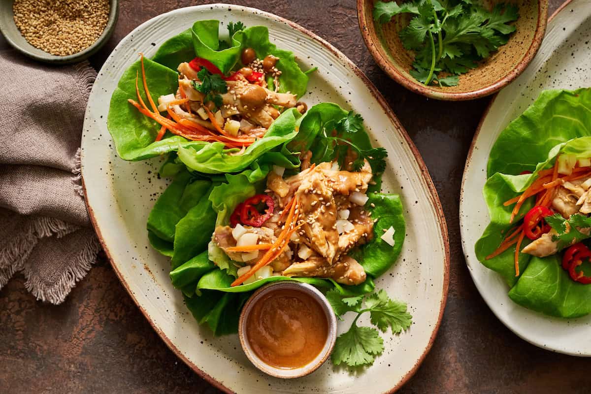overhead view of lettuce wraps with chicken and peanut sauce with fresh peppers, carrots and water chestnuts