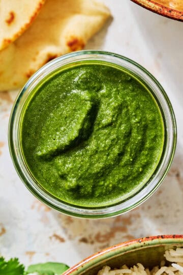 green chutney in a glass jar with naan bread