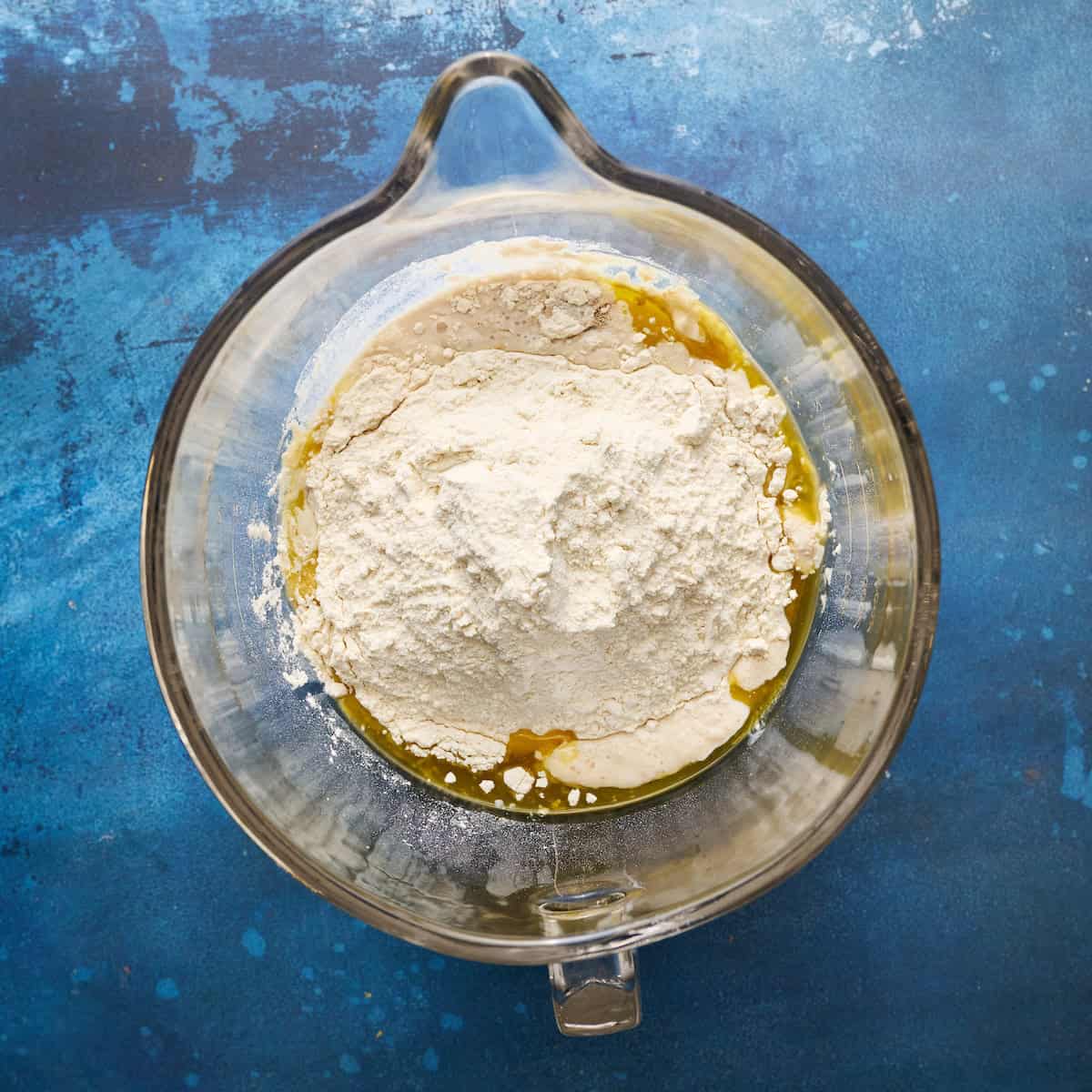 all ingredients added to a mixing bowl with yeast and sourdough discard