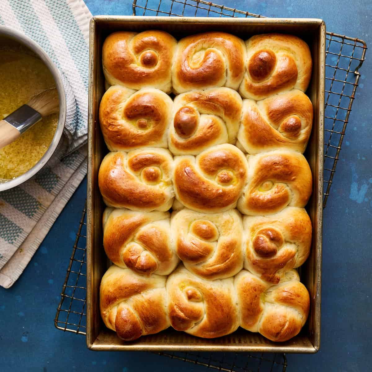 golden brown sourdough discard garlic knot rolls in a baking pan hot out of the oven