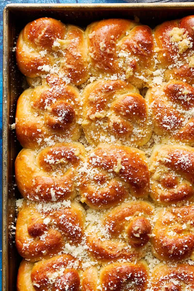 golden brown sourdough discard garlic knot rolls in a baking pan