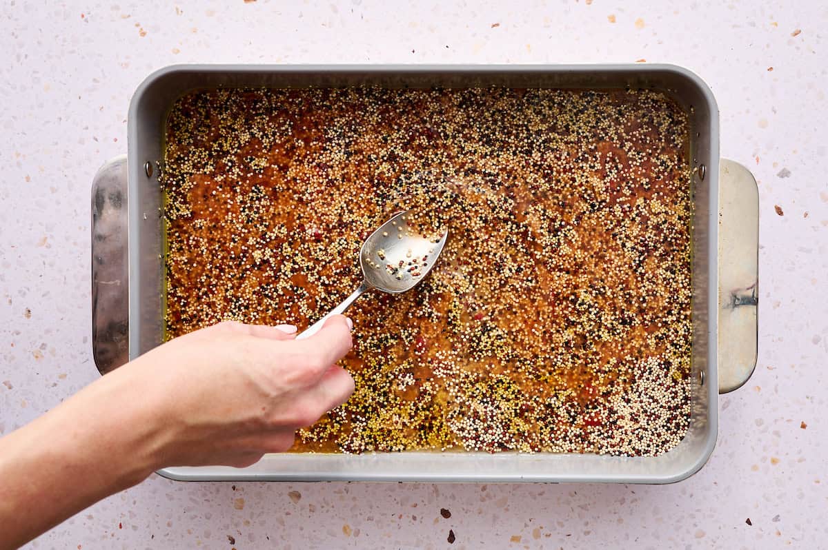 mixing the quinoa with broth and tomato paste
