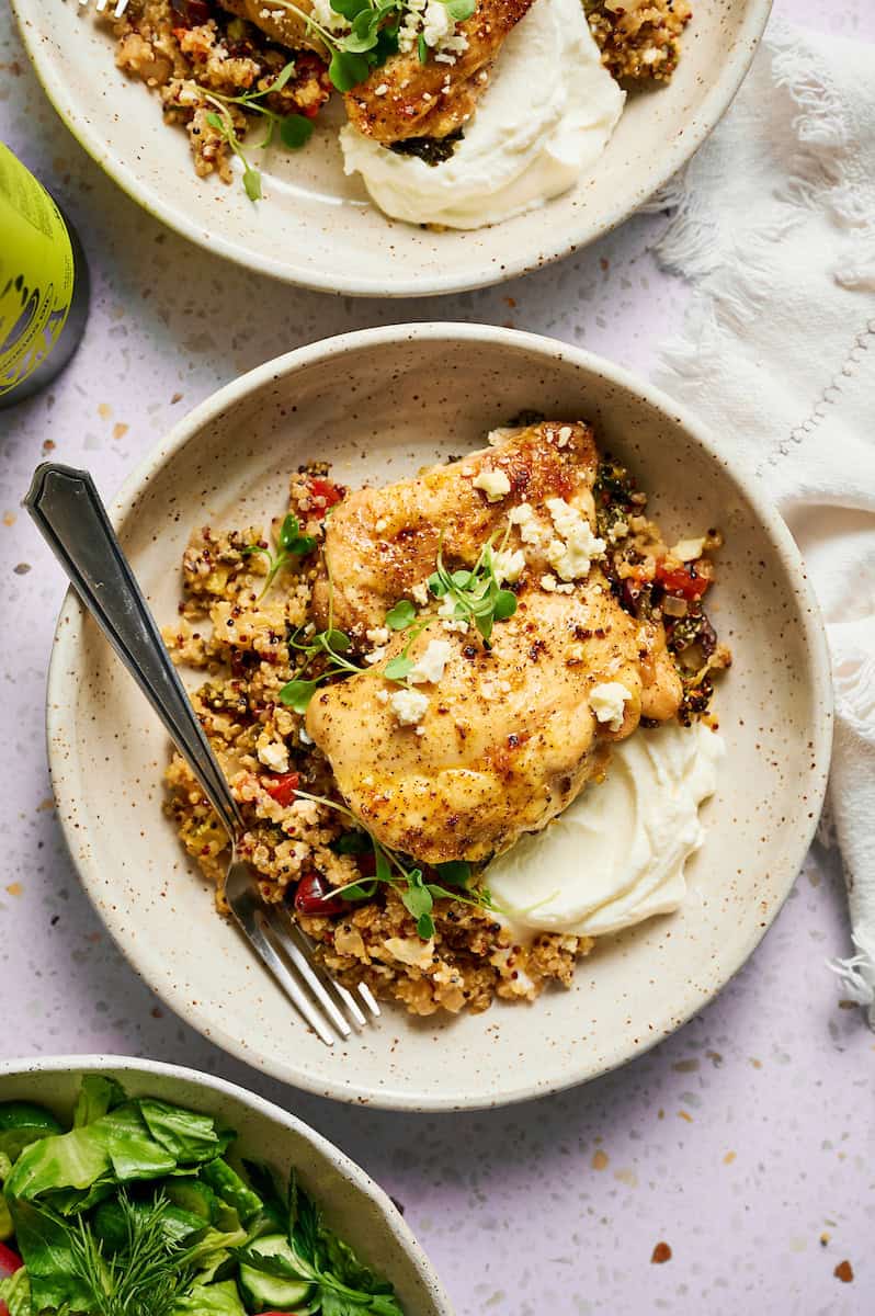 serving of quinoa chicken bake in a white plate with a side salad and greek yogurt