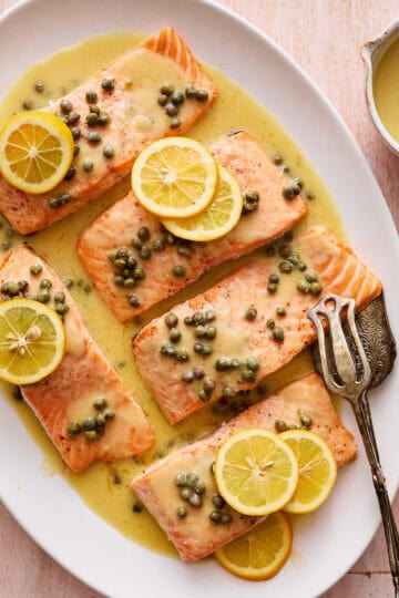 salmon piccata with capers and garnished with fresh lemon