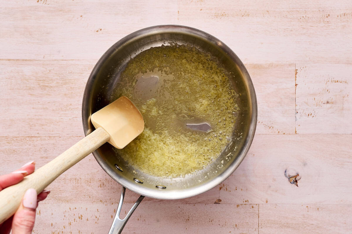 adding garlic to the butter in a saucepan