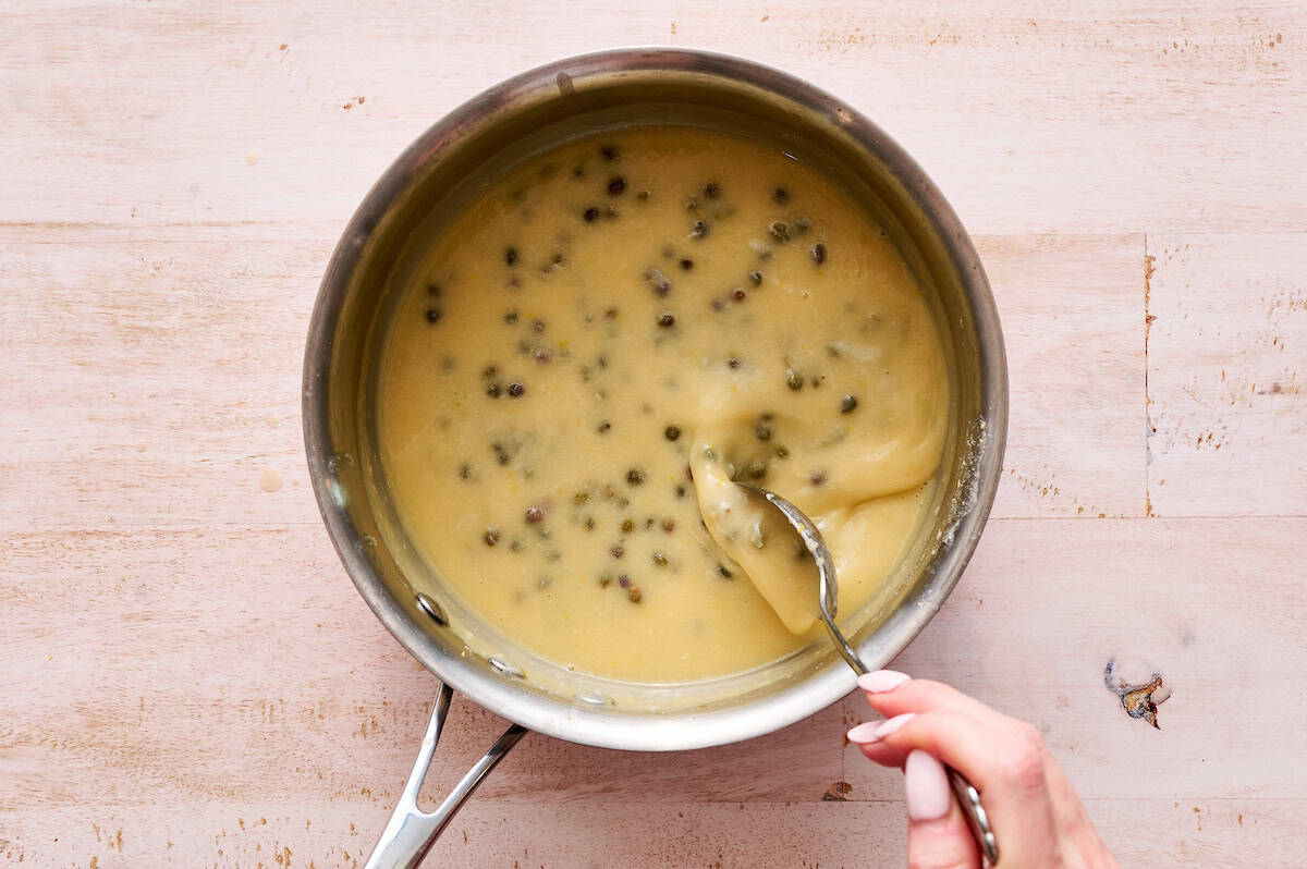 stirring piccata sauce in a saucepan