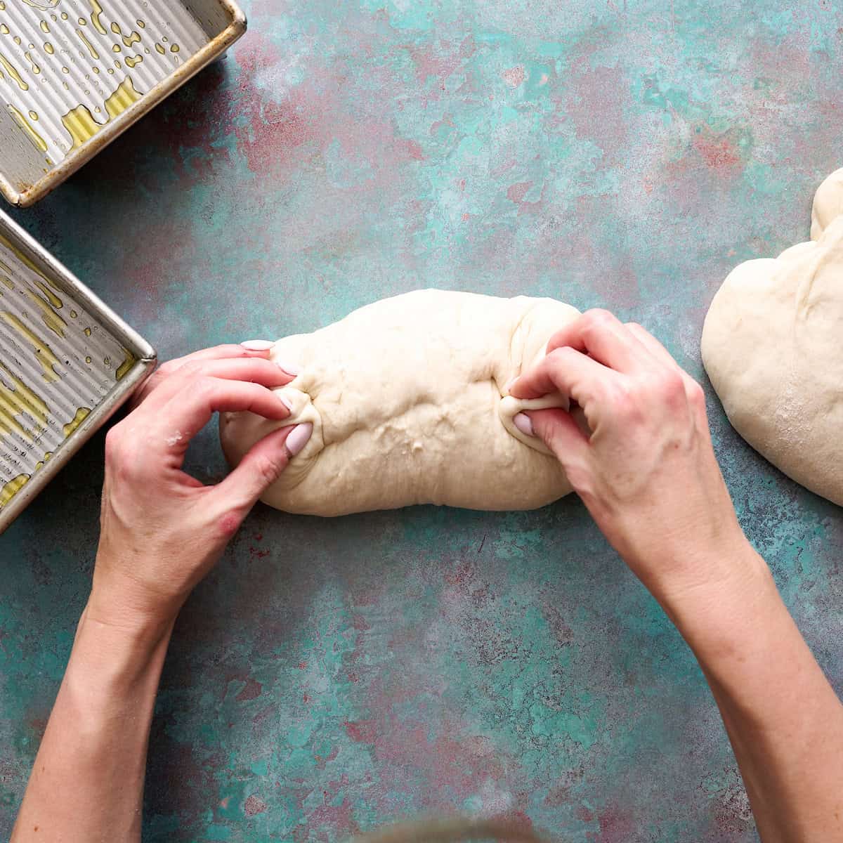 pinching the ends and seam of the loaf after rolling it
