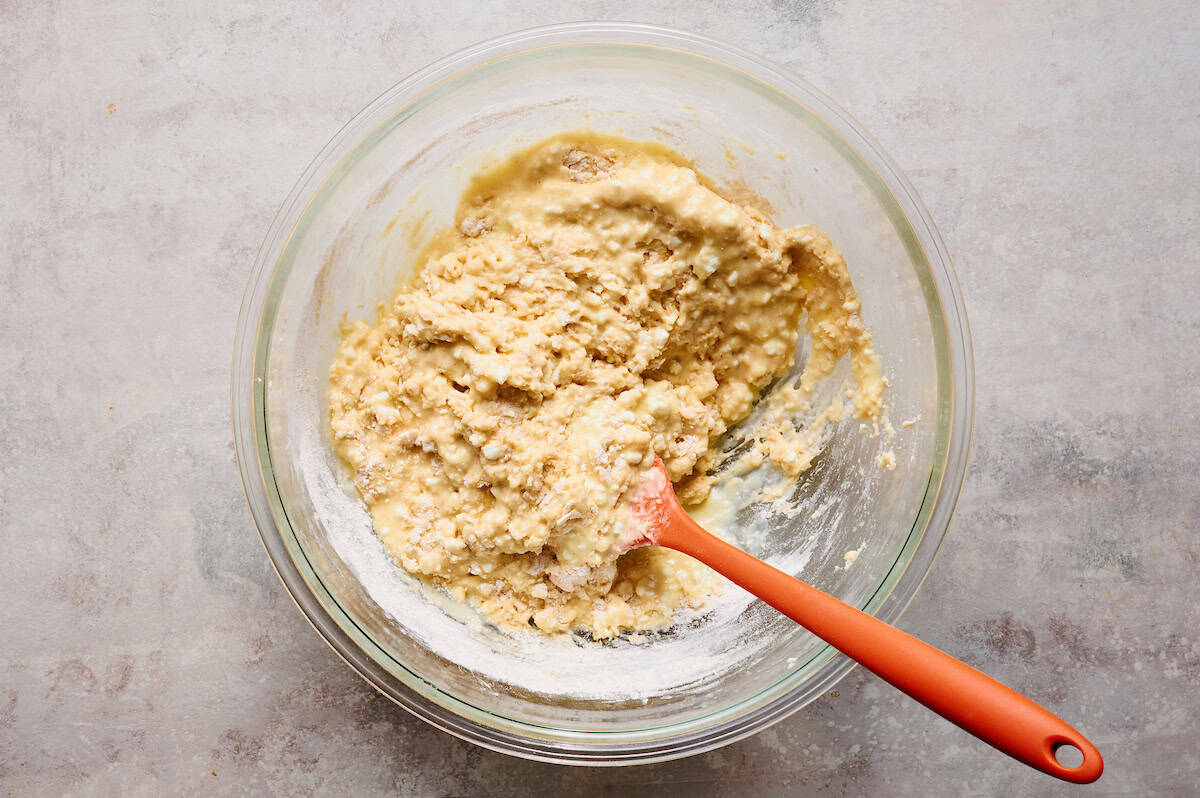 the dry and wet ingredients for the muffin batter combined in a glass mixing bowl