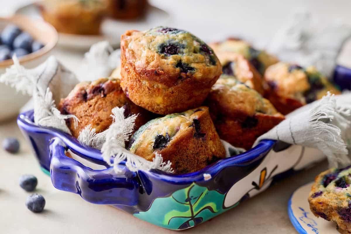 blueberry muffins made with high protein cottage cheese nestled in a blue serving tray