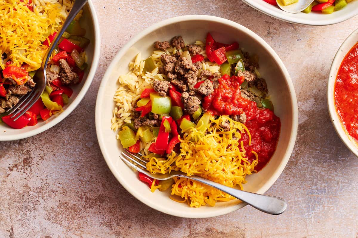 an assembled stuffed pepper bowl topped with shredded cheese