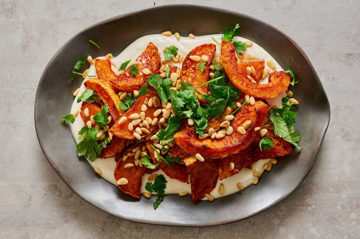 plated roasted squash with whipped ricotta and cilantro and pine nuts on the side
