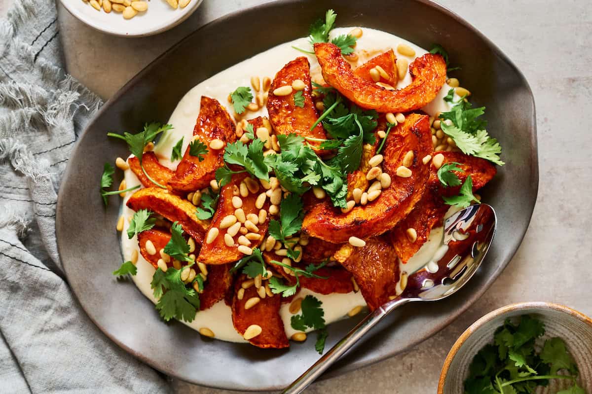 plated roasted squash with whipped ricotta and cilantro and pine nuts on the side