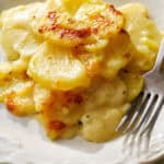 instant pot scalloped potatoes served on a plate with a fork next to it