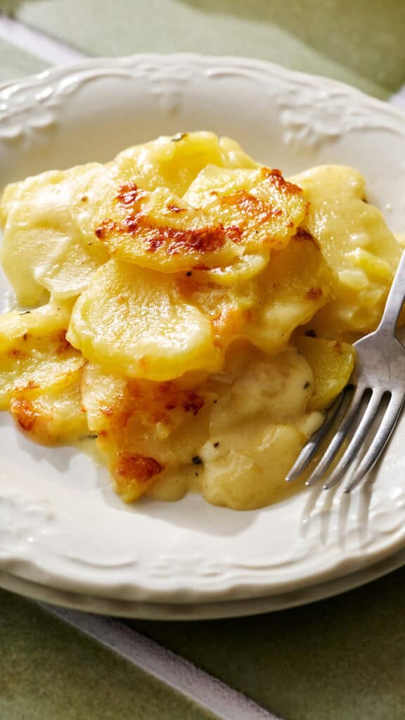 instant pot scalloped potatoes served on a plate with a fork next to it