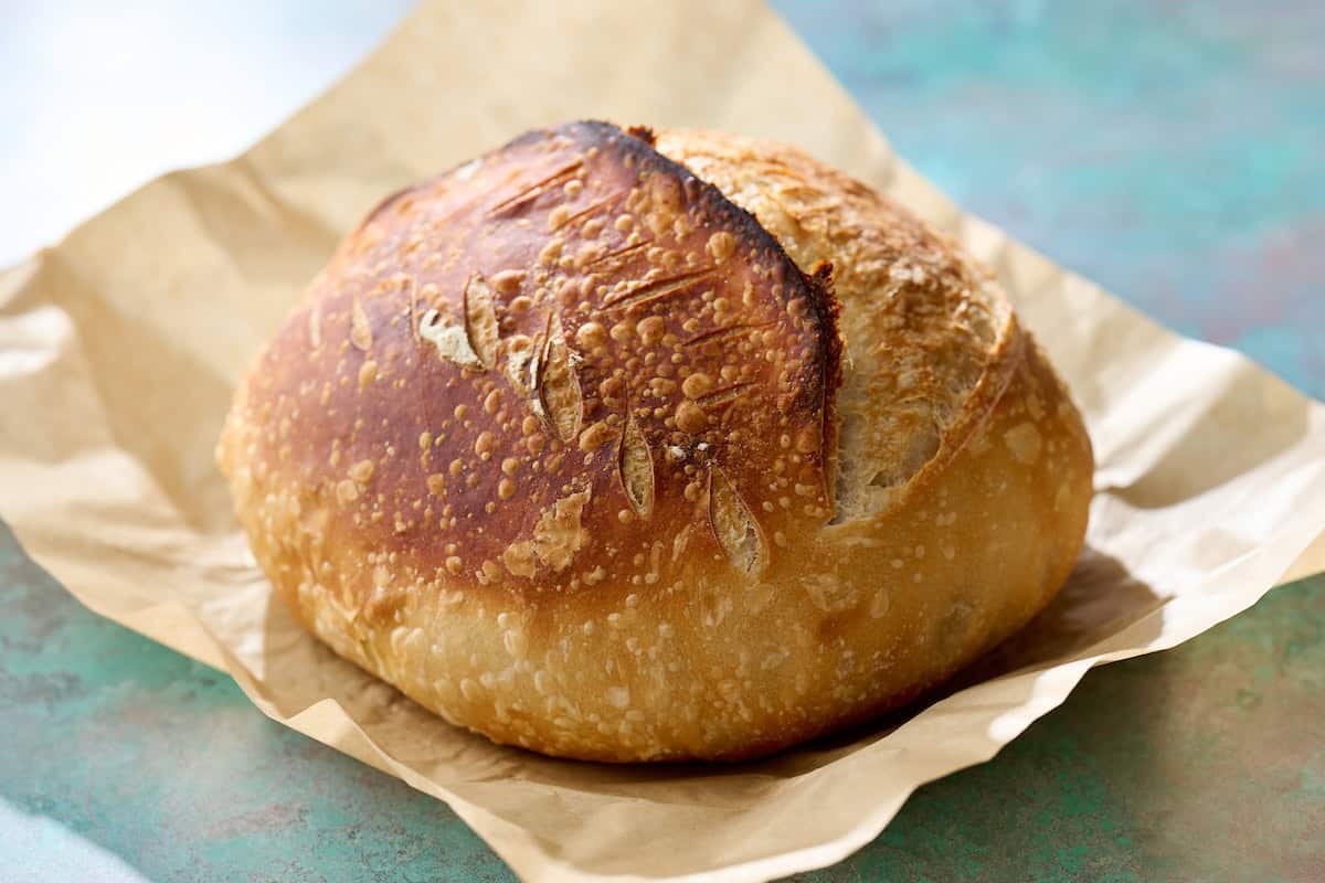 golden sourdough loaf on a parchment paper