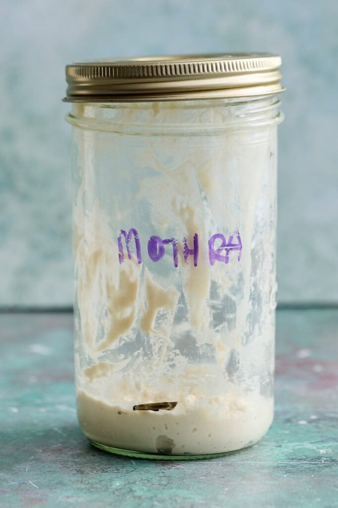 sourdough starter in a glass jar right after feeding with a line to mark where the starter begins
