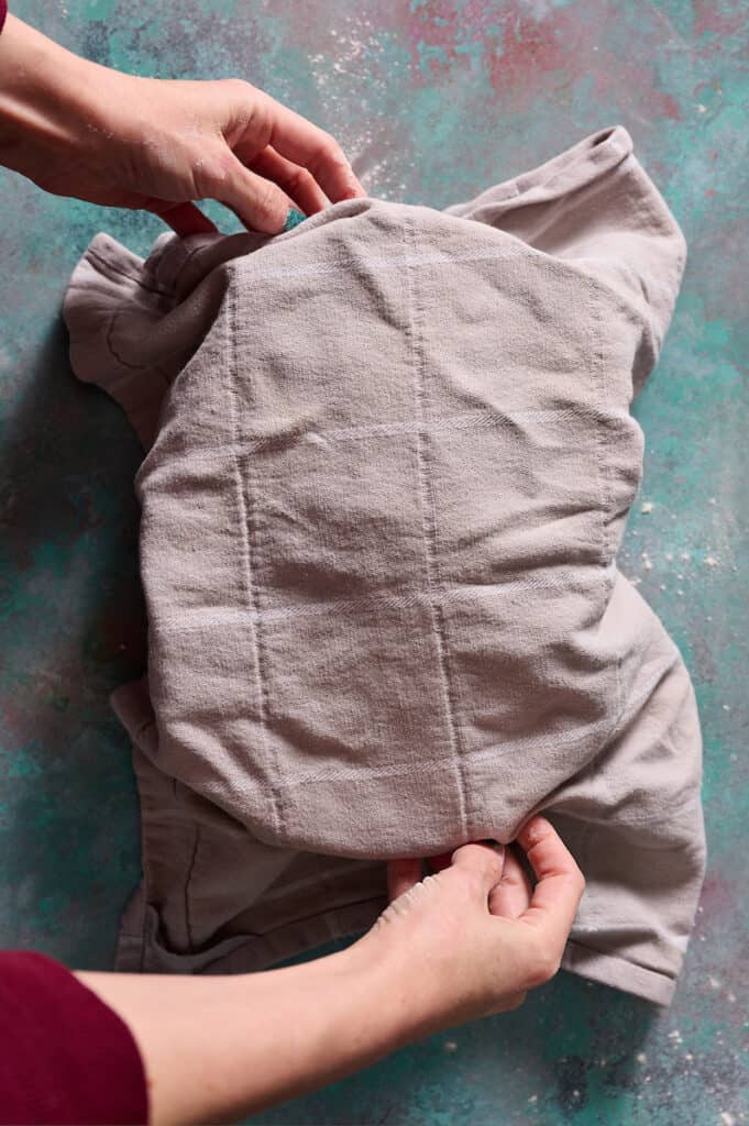 covering the shaped loaf in a banneton with a towel and placing in the fridge to cold proof