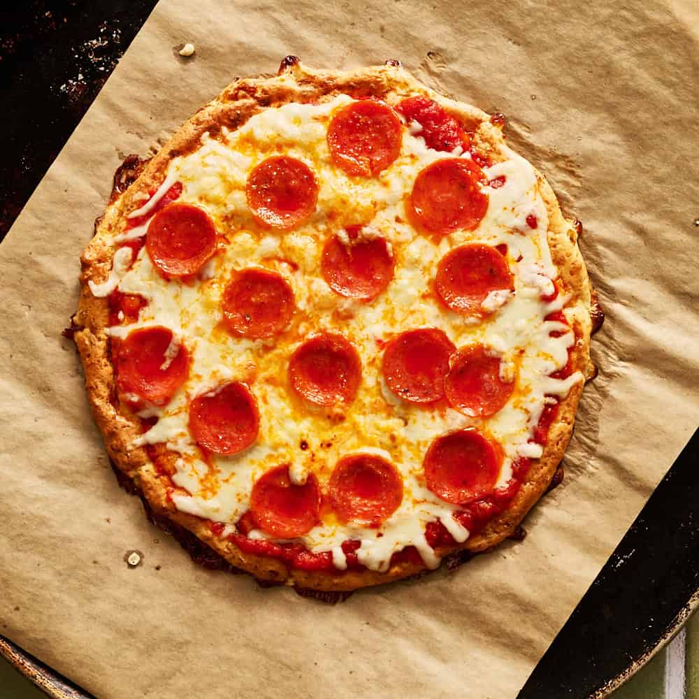 Baked cottage cheese pizza topped with pepperoni, cheese and sauce