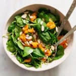 salad served in a large bowl with tongs