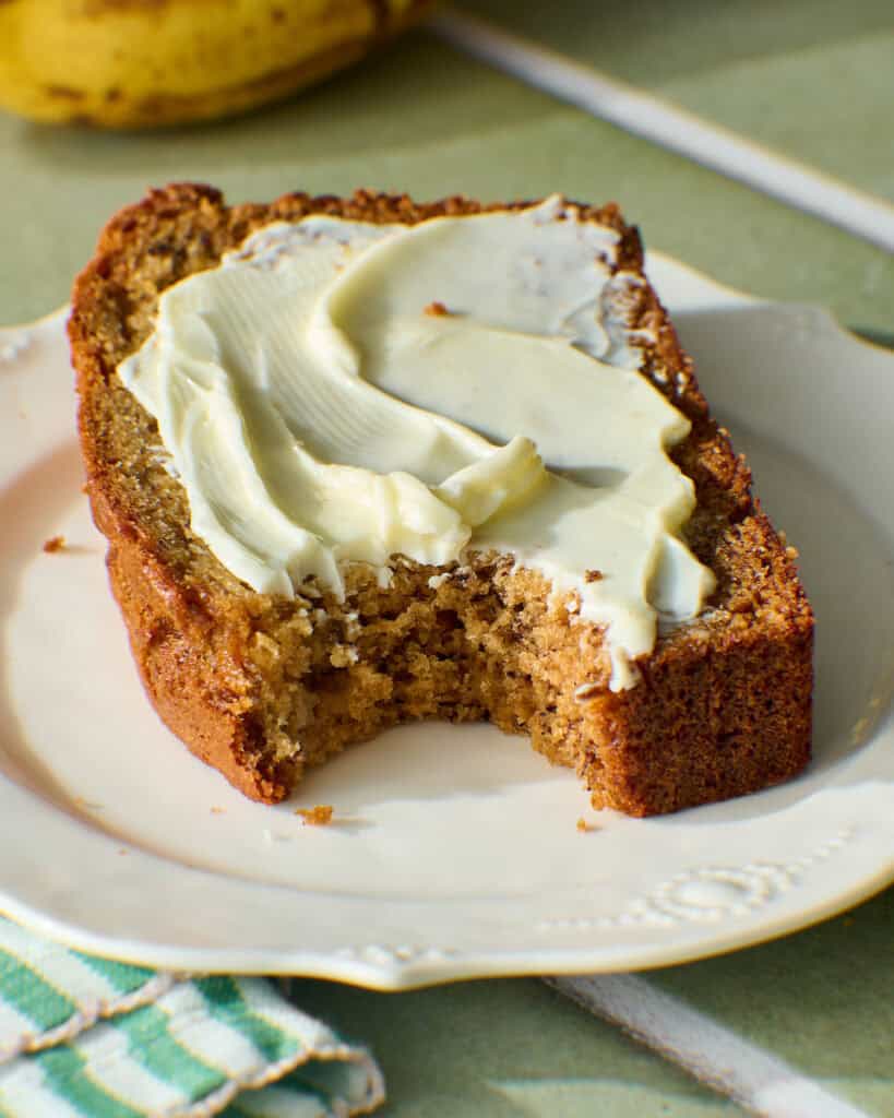 slice of sourdough discard banana bread smeared with butter
