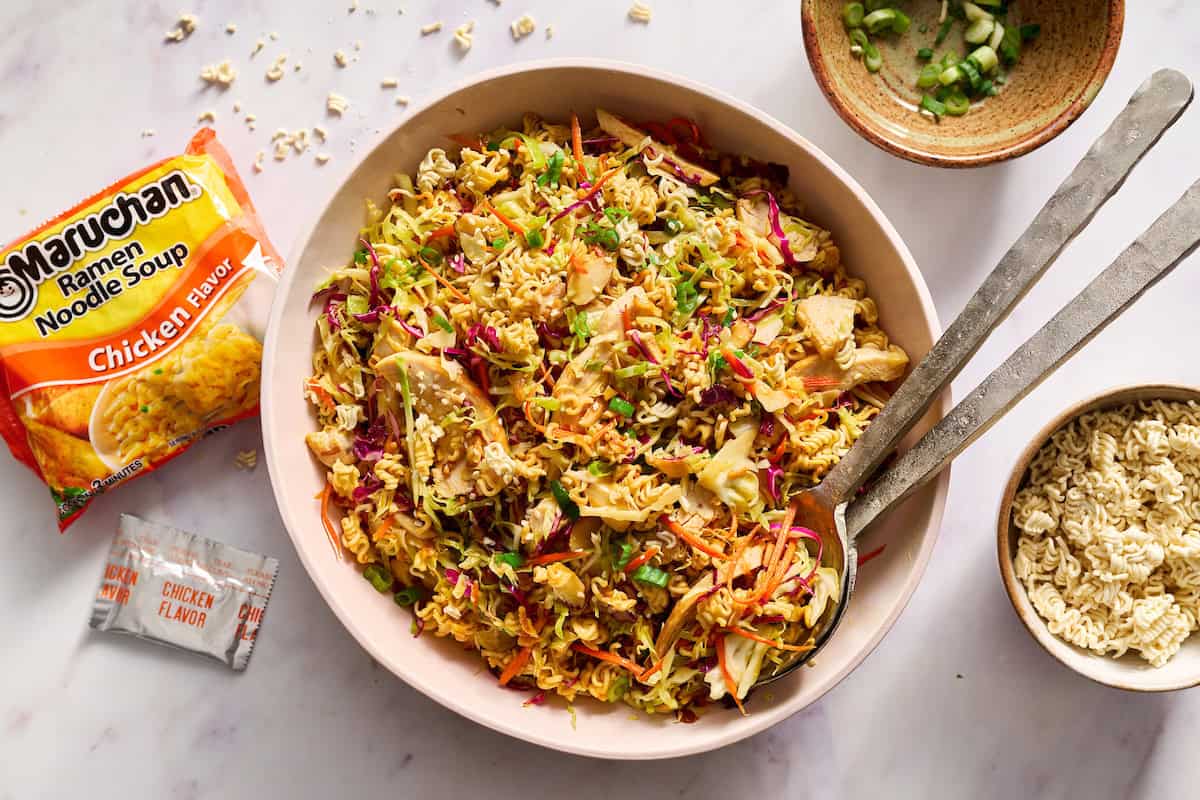 ramen noodle salad in a large serving bowl with tongs