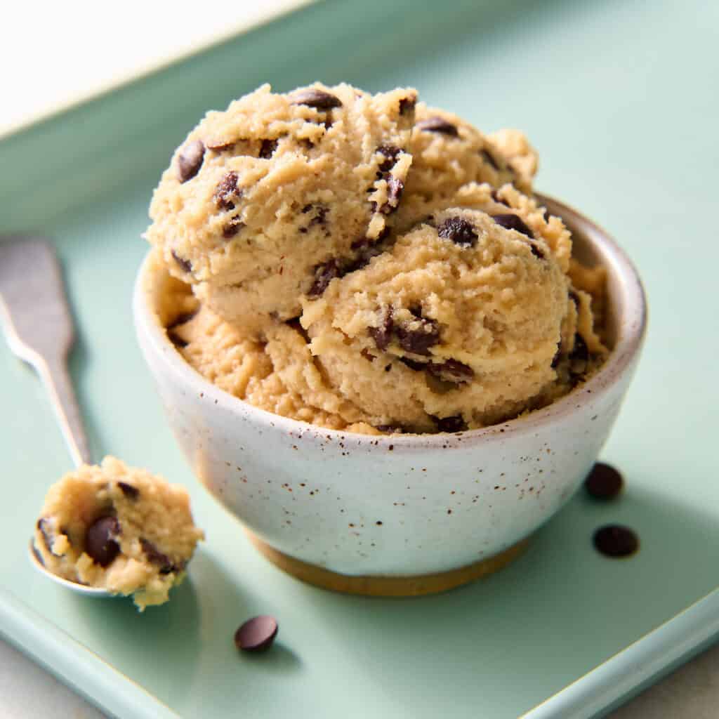 cottage cheese cookie dough scooped into a bowl with extra chocolate chips