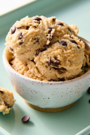 cottage cheese cookie dough scooped into a bowl with extra chocolate chips